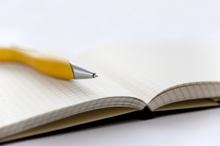 Yellow pen and notebook on the white backgroundの写真素材