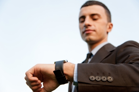 Man checking the time on the background of skyの写真素材