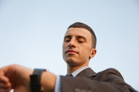 Man checking the time on the background of skyの写真素材