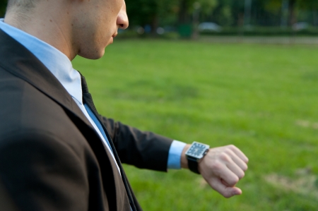 Man checking the time in the parkの写真素材