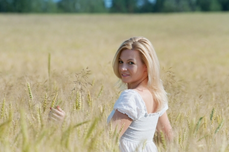 Beautiful woman smiles in the wheat fieldの写真素材