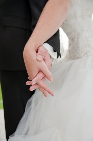 Bride and groom holding hands in the parkの写真素材