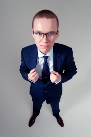 Portrait of businessman holding his jacket on gray backgroundの写真素材