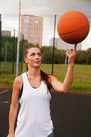 Sexy Woman Throw Basketball While Standing On Sport Playgroundの写真素材