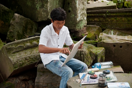 SIEM REAP, CAMBODIA - July 17, 2013  Young asian boy draw a picture for sale on July 17, 2013, near Siem Reap, Cambodiaのeditorial素材