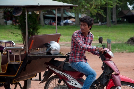 SIEM REAP, CAMBODIA - July 18, 2013  Asian boy with motorbike on July 18, 2013, near Siem Reap, Cambodiaのeditorial素材