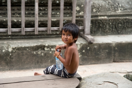 SIEM REAP, CAMBODIA - July 17, 2013  Little asian boy with bottle of water posing in Angkor Wat temple, July 17, 2013, Siem Reap, Cambodia のeditorial素材