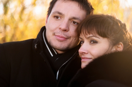 Young couple on the yellow leaves backgroundの写真素材