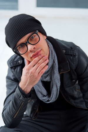 Young smiling man in casual clothes sitting on the white floorの写真素材