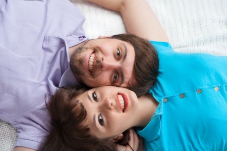 Cropped view of a young couple lying in bed and looking upの写真素材