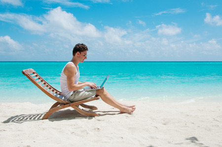 Man relaxing at the beach with laptop. Maldives island, ocean viewの写真素材