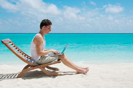 Man relaxing at the beach with laptop. Maldives island, ocean viewの写真素材