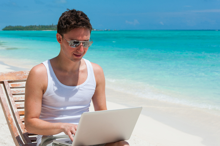Man sitting at the beach with laptop. Maldives island, ocean viewの写真素材