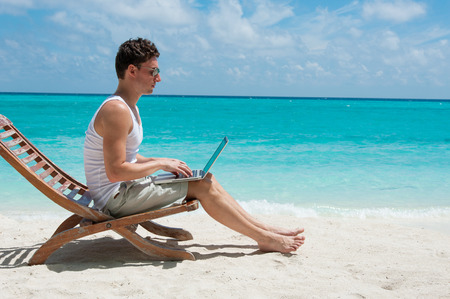 Man relaxing at the beach with laptop. Maldives island, ocean viewの写真素材