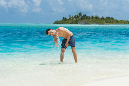 Man splash water of the ocean at the background of island, Maldivesの写真素材
