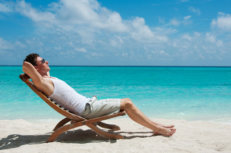 Man relaxing on beach, ocean view, Maldives islandの写真素材