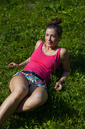Beautiful smiling woman relaxing on grassの写真素材