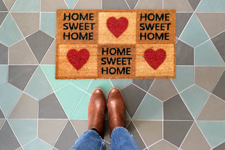 Designer Welcome Entry Doormat Placed on Colorful Tiles Floor with Brown Shoesの写真素材