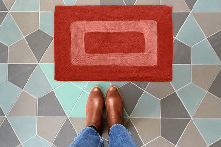 Designer Welcome Entry Doormat Placed on Colorful Tiles Floor with Brown Shoesの写真素材