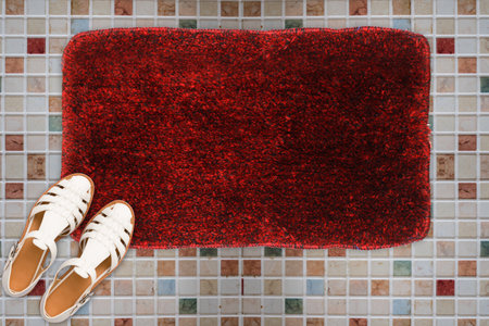 Designer Welcome Entry Doormat Placed on Square Marble Floor with White Ladies Sandlesの写真素材