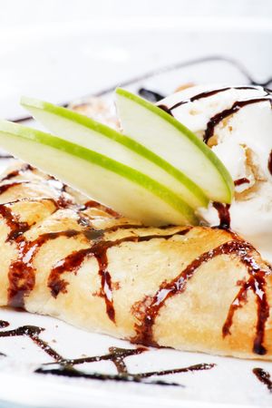 apple cake and ice-cream on a white plateの写真素材