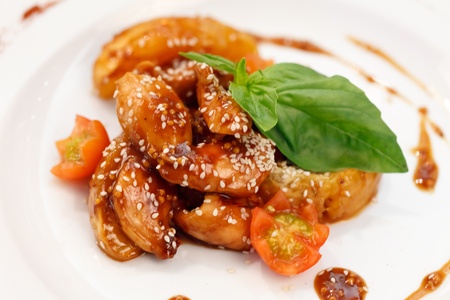 portion of sesame chicken served on a white plate の写真素材