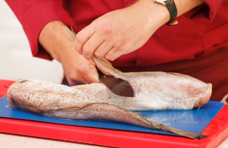 chef in restaurant slicing raw fishの写真素材