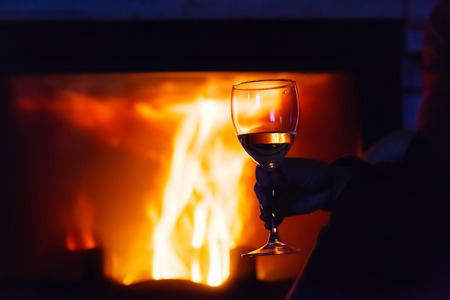 glass of  wine beside the fireの写真素材