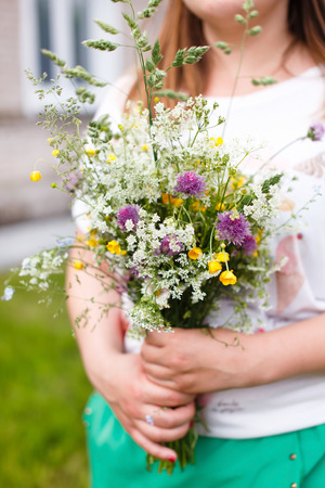 Woman holding wild flowersの写真素材