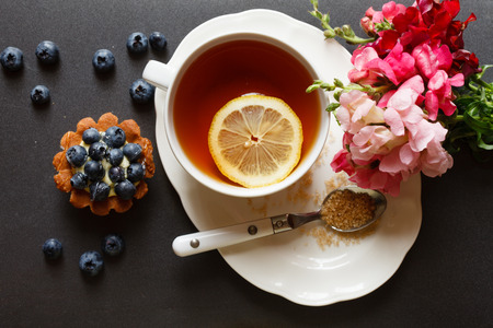 cup of tea with cake and flowersの写真素材