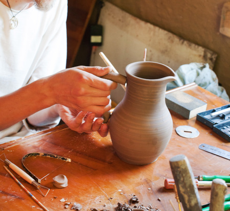 young men making clay potの写真素材