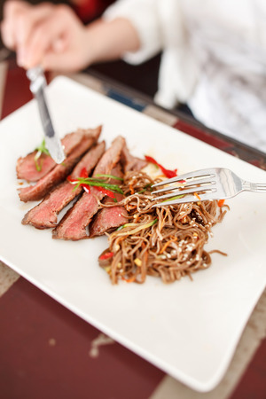 woman eating steakの写真素材