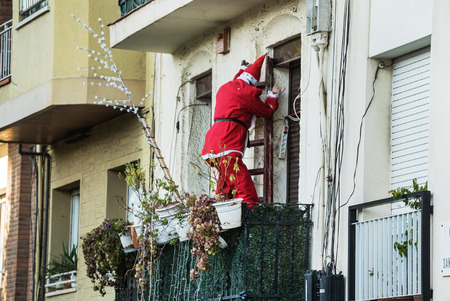 Barcelona, Spain - JAN 4, 2016: A doll of Santa or Father Christmas hanging from a balcony.の写真素材