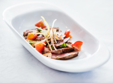 sliced beef with vegetable garnishの写真素材