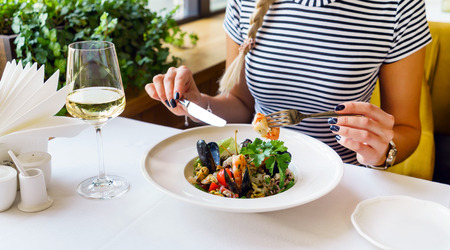 lady eating seafood pastaの写真素材