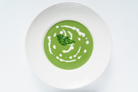 spinach cream soup in white bowlの写真素材