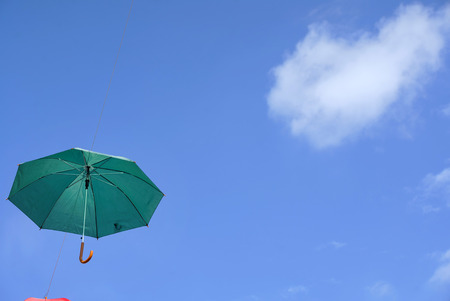 umbrella flying on a blue skyの写真素材