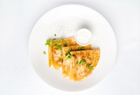 Crepes Suzette sour cream on white plate over white background, copy space. Delicious homemade Crepes for breakfast. - Imageの写真素材