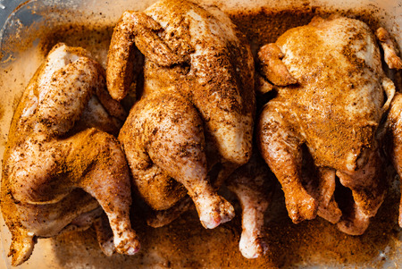 raw chicken with spices on parchment reading for cooking, horizontal imageの写真素材