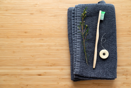 Eco natural bamboo toothbrushes and biodegradable silk  dental floss on the black towel,  sustainable lifestyle concept.の写真素材