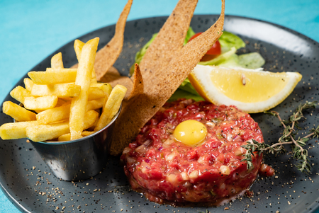 Beef tartare with egg yolk and french friesの写真素材