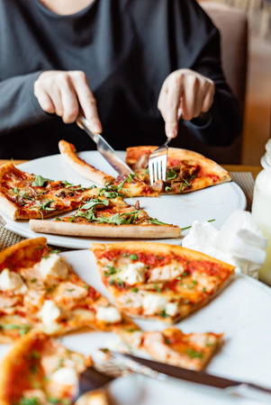 friends eating pizza in a indoor cafeの写真素材