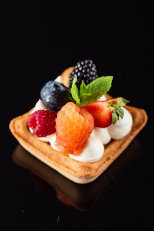 Fresh Fruit Tart with berries isolated on black backgroundの写真素材