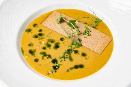 cream soup with pesto on the whtie plateの写真素材