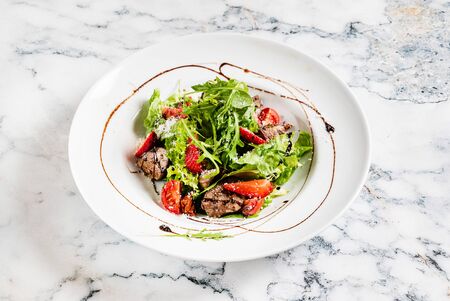 Salad with strawberries and duck liverの写真素材