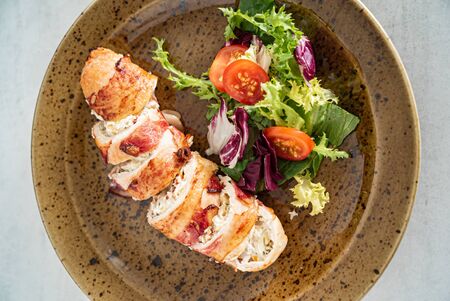 stuffed chicken wiht bacon and saladの写真素材