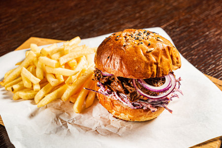 Burger with french fries on the parchment
