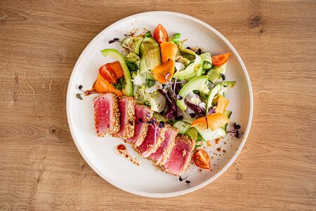 tuna steak with fresh salad on teh wooden backgroundの写真素材