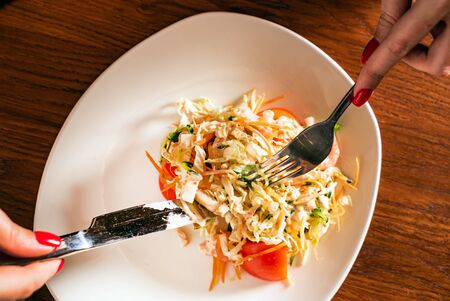 woman eating salad with chicken and vegetablesの写真素材