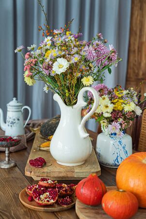 autumn vegetables and flowers in the kitchenの写真素材